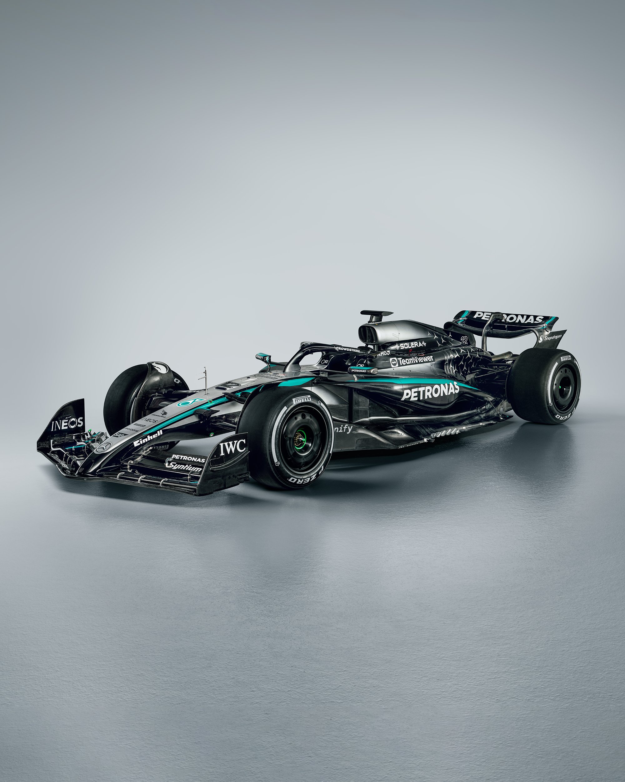 A three-quarter front angle of the W16 in the studio showing off the silver and black livery with PETRONAS green accents